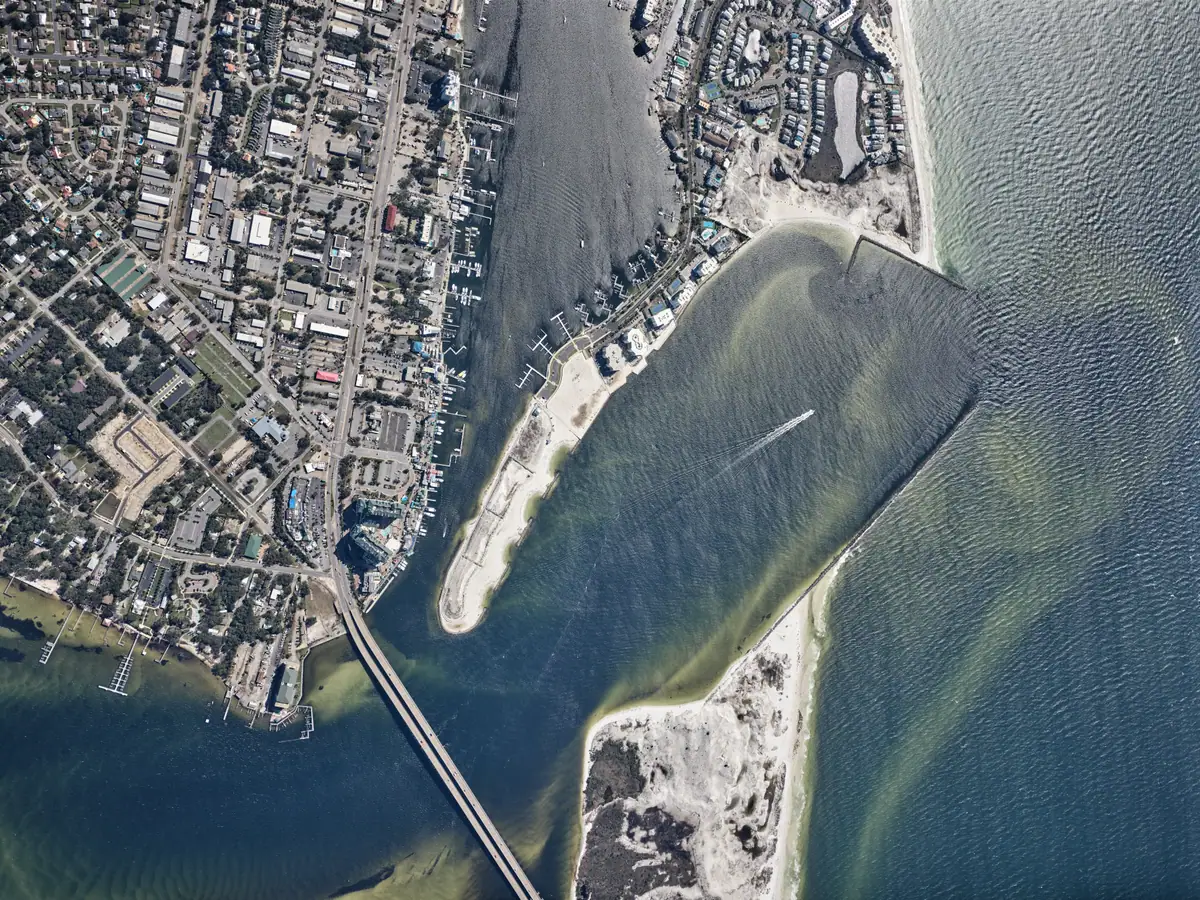 Aerial view of waterfront businesses, docks, rooftops, and boats around Destin Harbor on October 11, 2026.