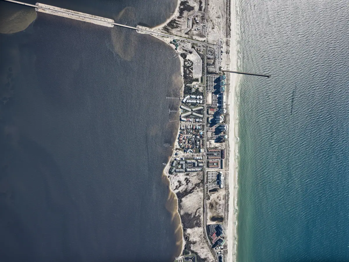 Aerial survey of Navarre Beach condominiums, residential rooftops, and the beach after Isaias.