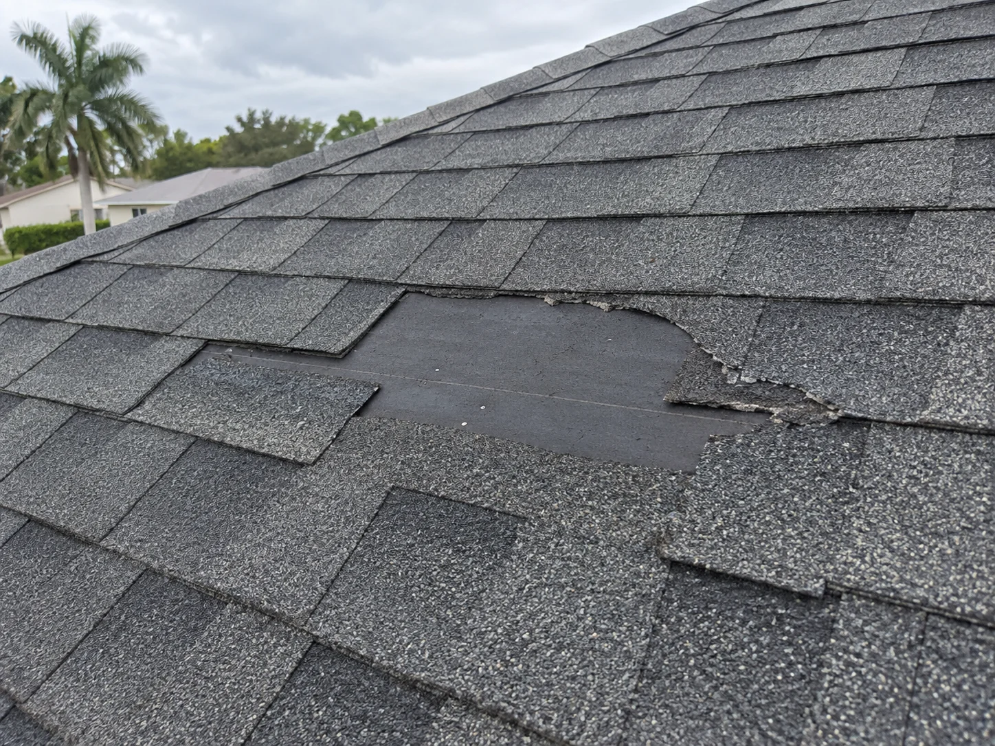 AI-generated example of missing roof shingles, used in a fictional sample report.