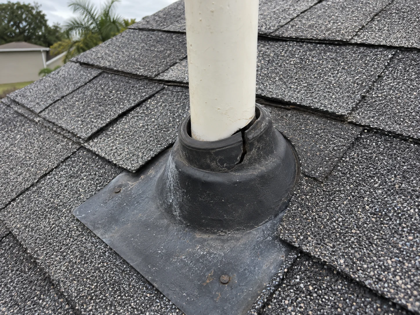 AI-generated example of a split rubber roof boot with an open gap beside a PVC vent pipe.