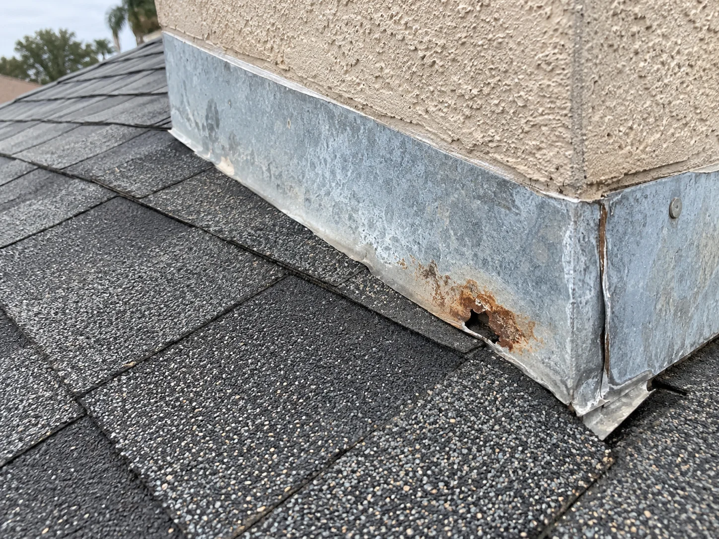 AI-generated example of chimney-base flashing with rust and an irregular perforation.