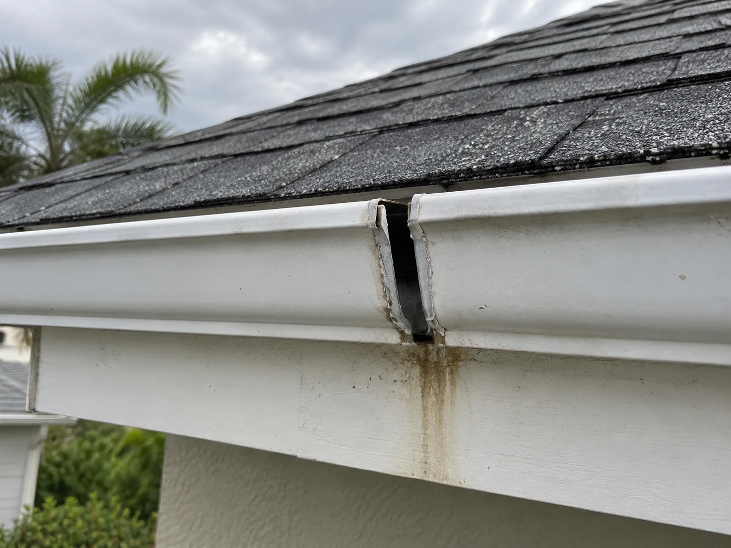 AI-generated example of a separated white gutter splice with staining on the fascia below.
